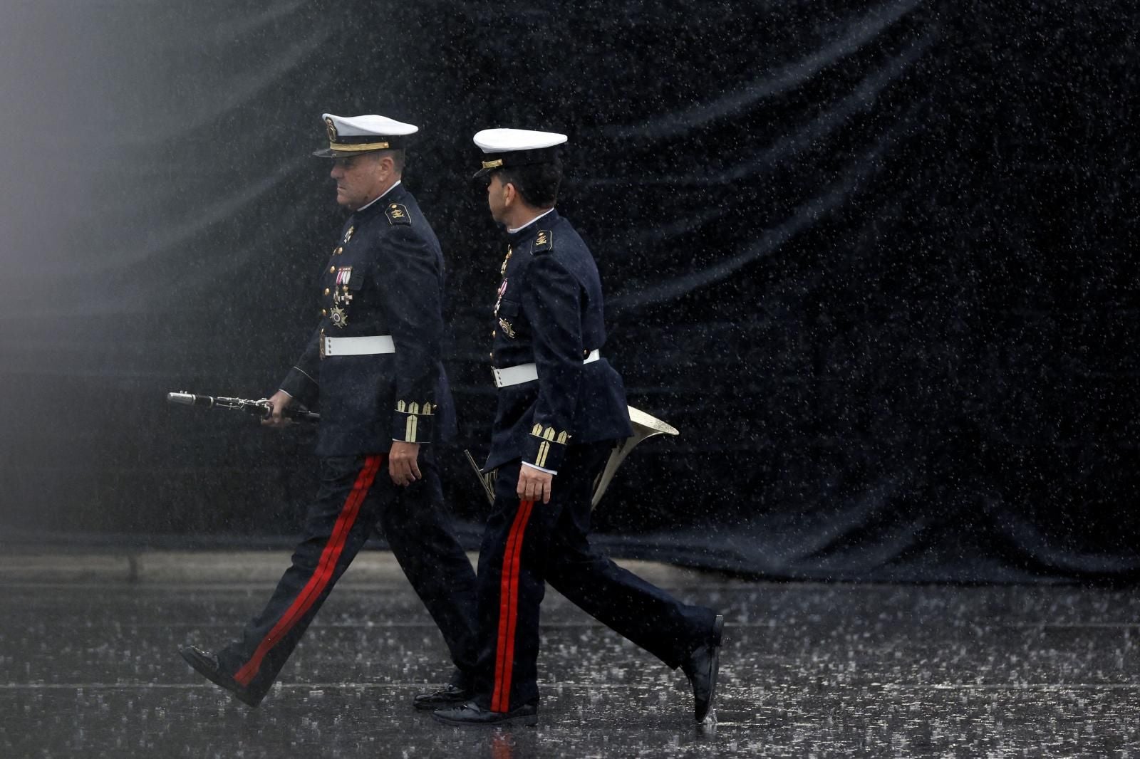 Dos integrantes de las Fuerzas Armadas durante los preparativos del desfile, que se ha tenido que modificar sustancialmente por la lluvia