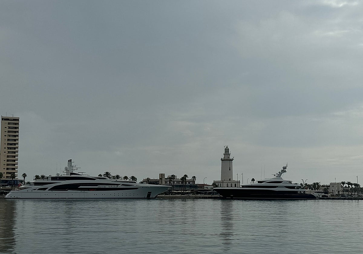 Dos megayates en el Puerto de Málaga con La Farola como fondo