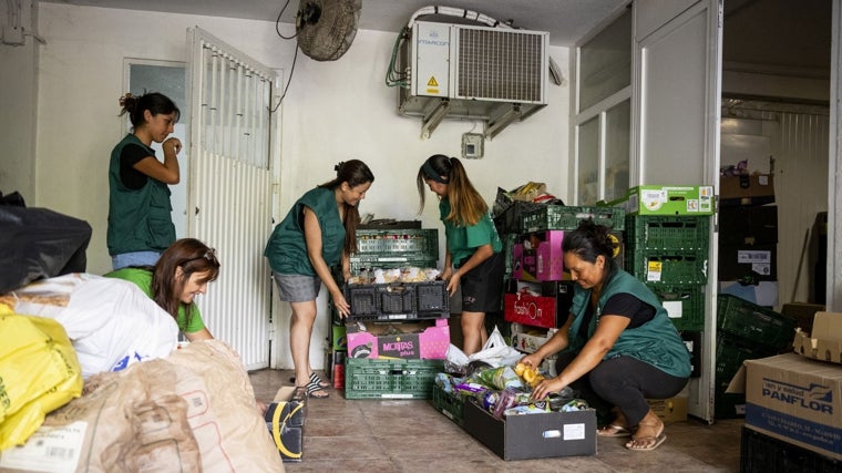 Varias voluntarias organizan la comida que se va a repartir