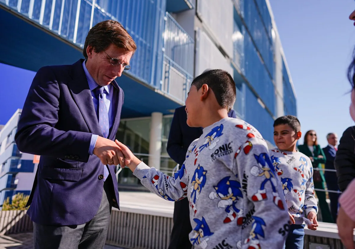 Almeida saluda a dos niños durante el acto de entrega de las últimas llaves