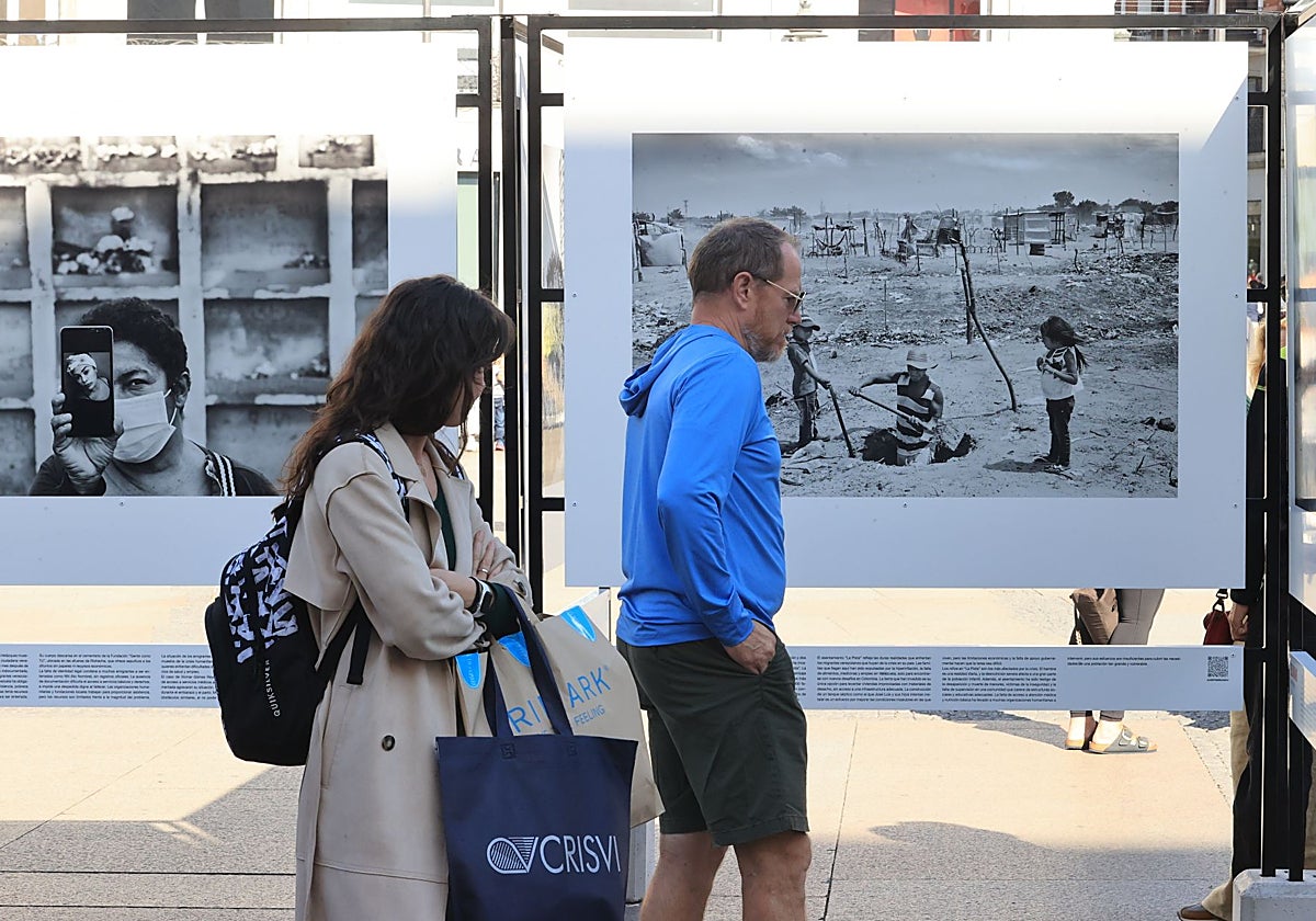 Dos ciudadanos contemplan las imágenes de la exposición 'Bolivariano'
