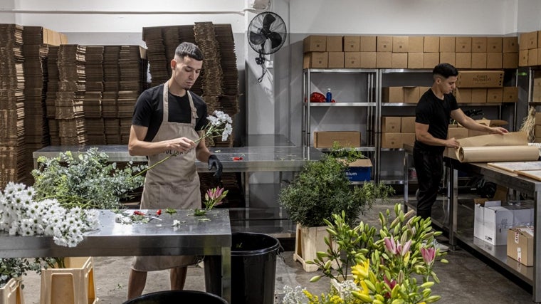 Empleados de Flores Solidarias preparan varios pedidos