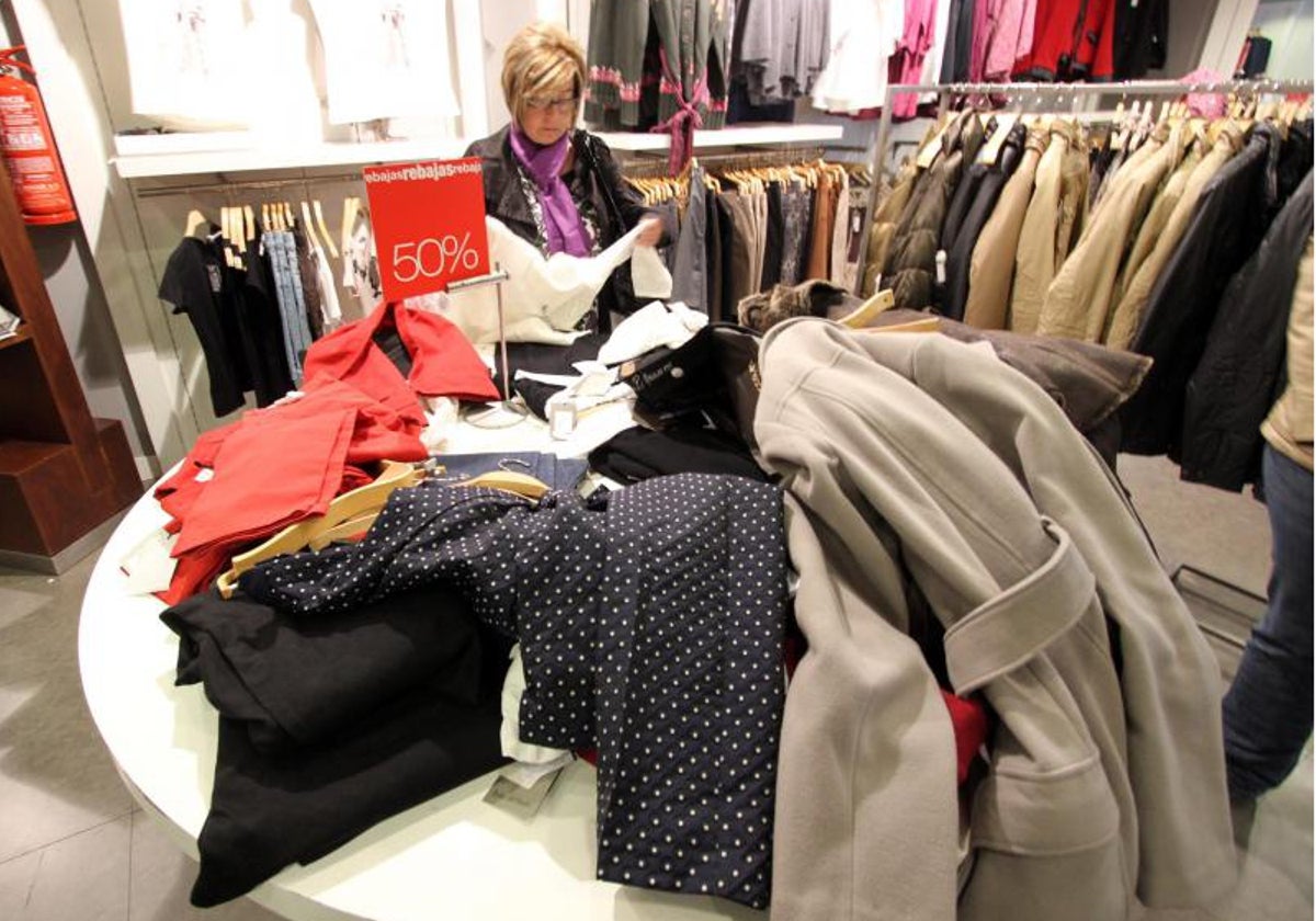 Una mujer mira ropa en una tienda de Alicante