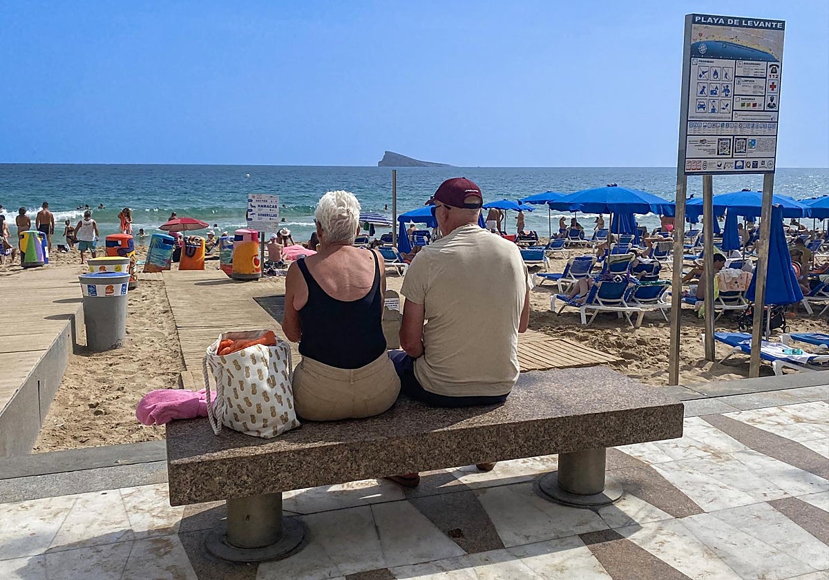 Una pareja de jubilados extranjeros junto a la playa en Benidorm