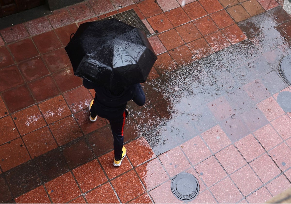 Un hombre camina bajo un paraguas durante el temporal