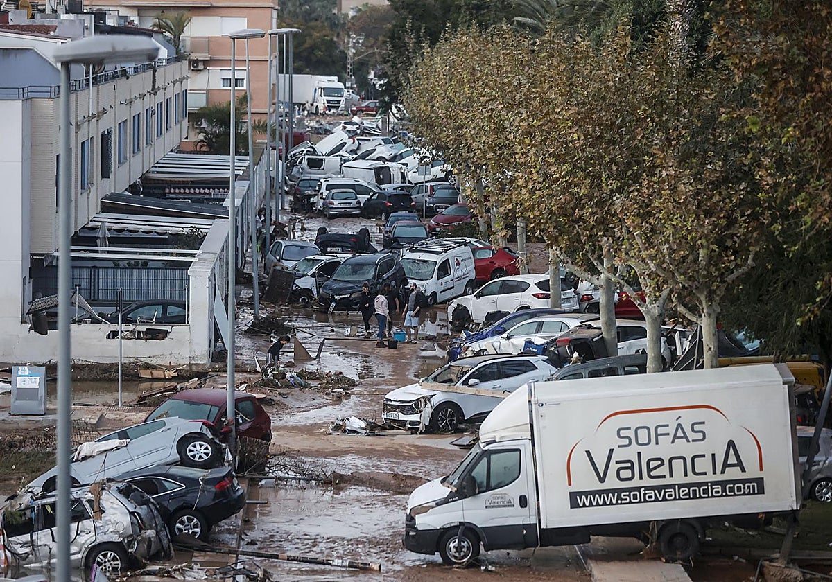 Afectados por la DANA en Alfafar (Valencia), con vehículos amontonados y otros destrozos