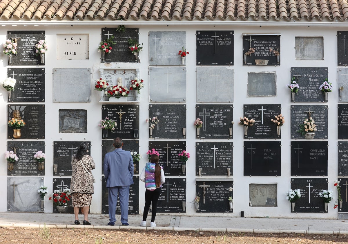 Una familia delante de unos nichos