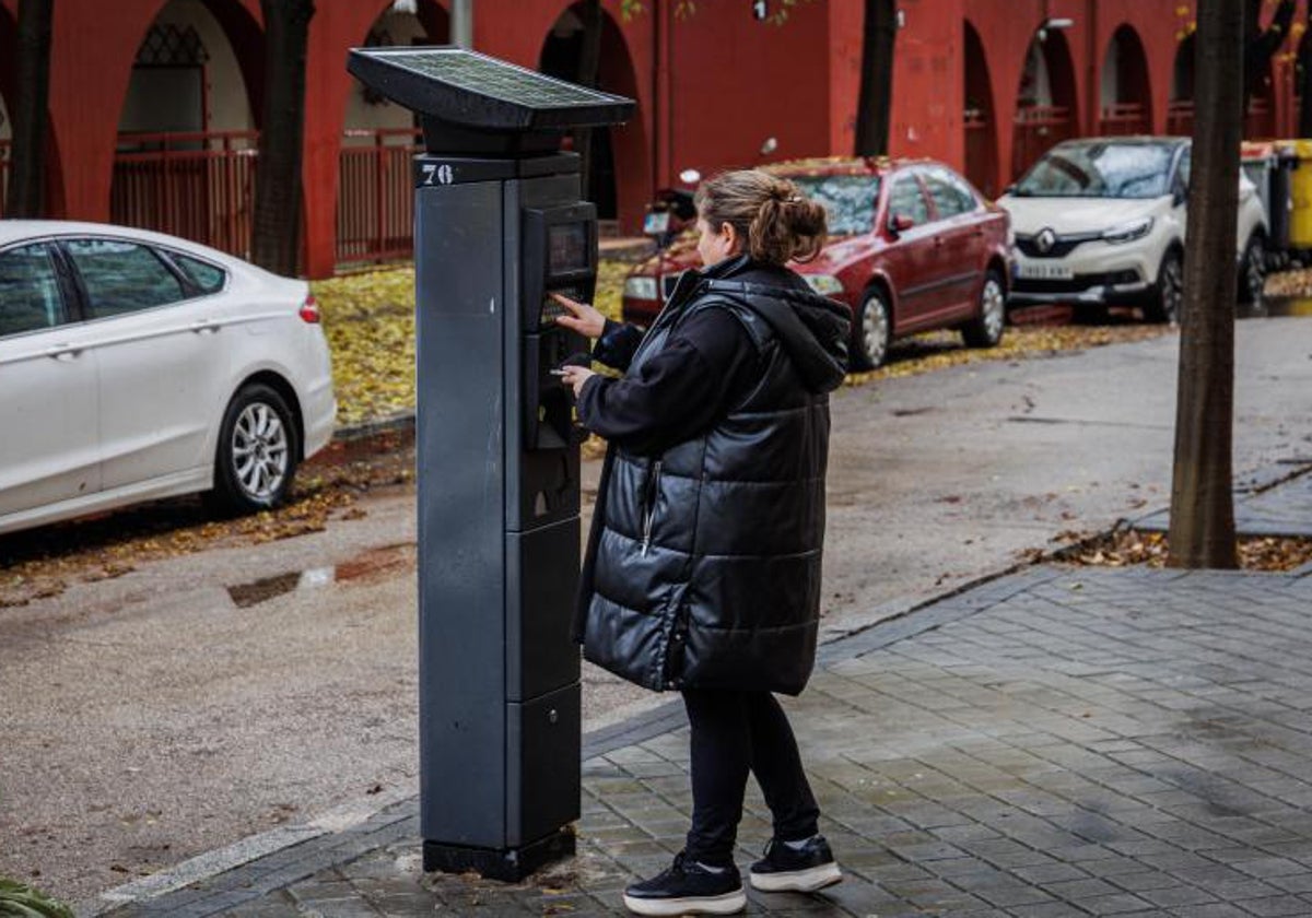 Una mujer utiliza un parquímetro en Alto de Extremadura