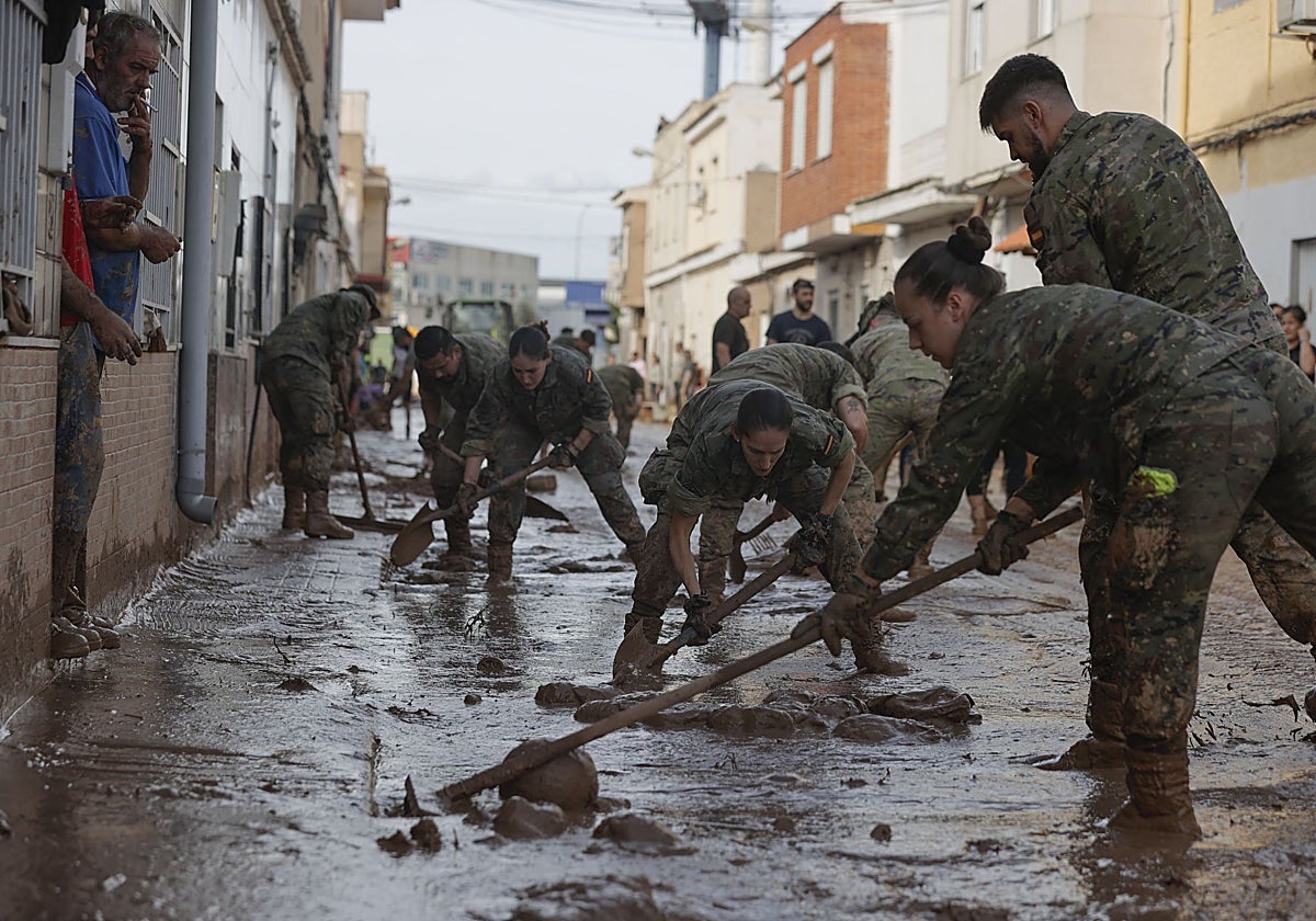 Imagen de varios soldados del regimiento 21 de marines trabajando este viernes en las labores de retirada del lodo acumulado en la Masía del Oliveral, en Ribarroja de Turia