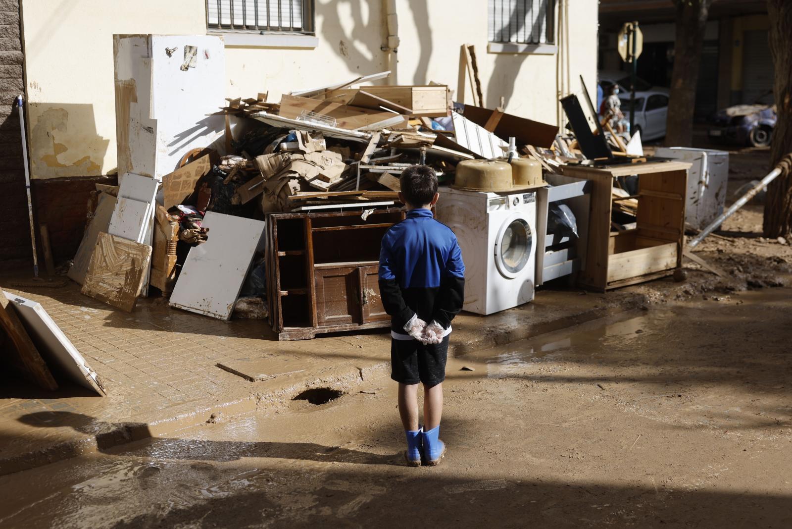Un niño observando los restos de su casa en Masanasa, en Valencia
