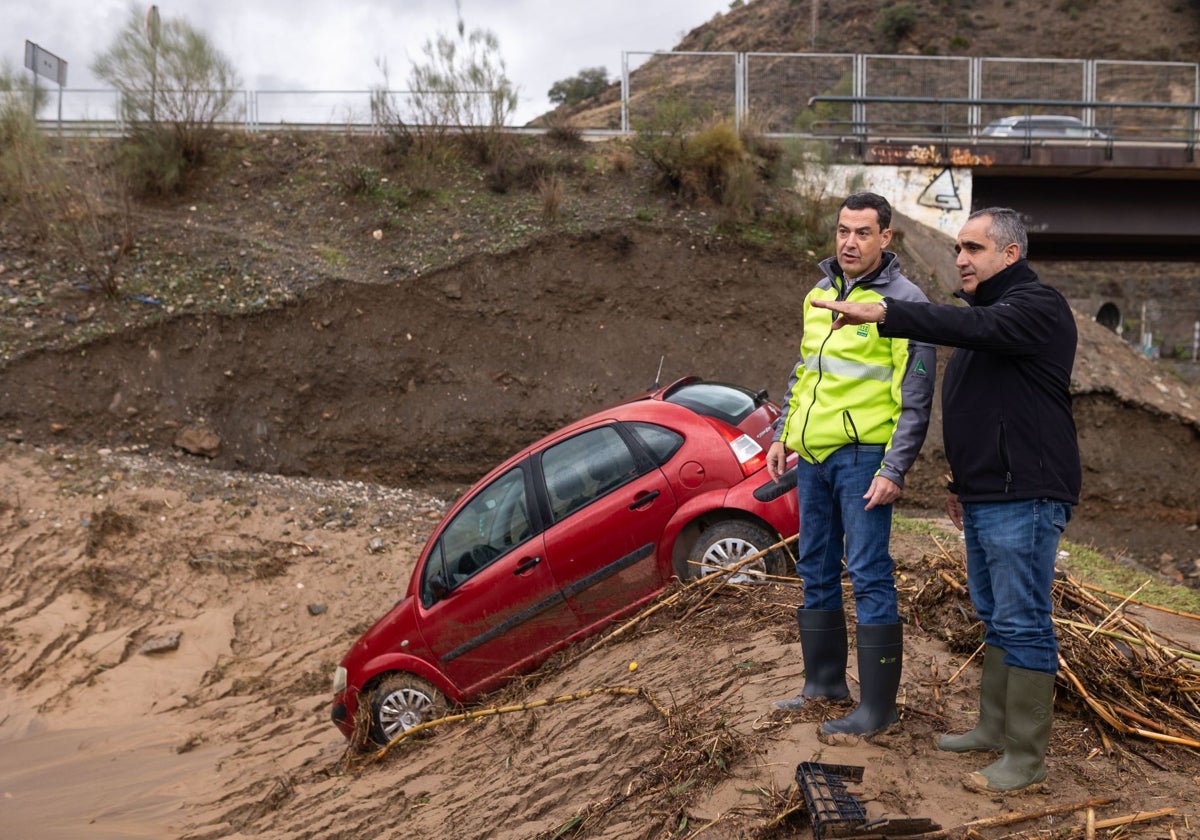 El presidente de la Junta de Andalucía, Juanma Moreno (i), junto al alcalde de Álora, Francisco Martínez (d), durante su visita tras el desborde del río Guadalhorce