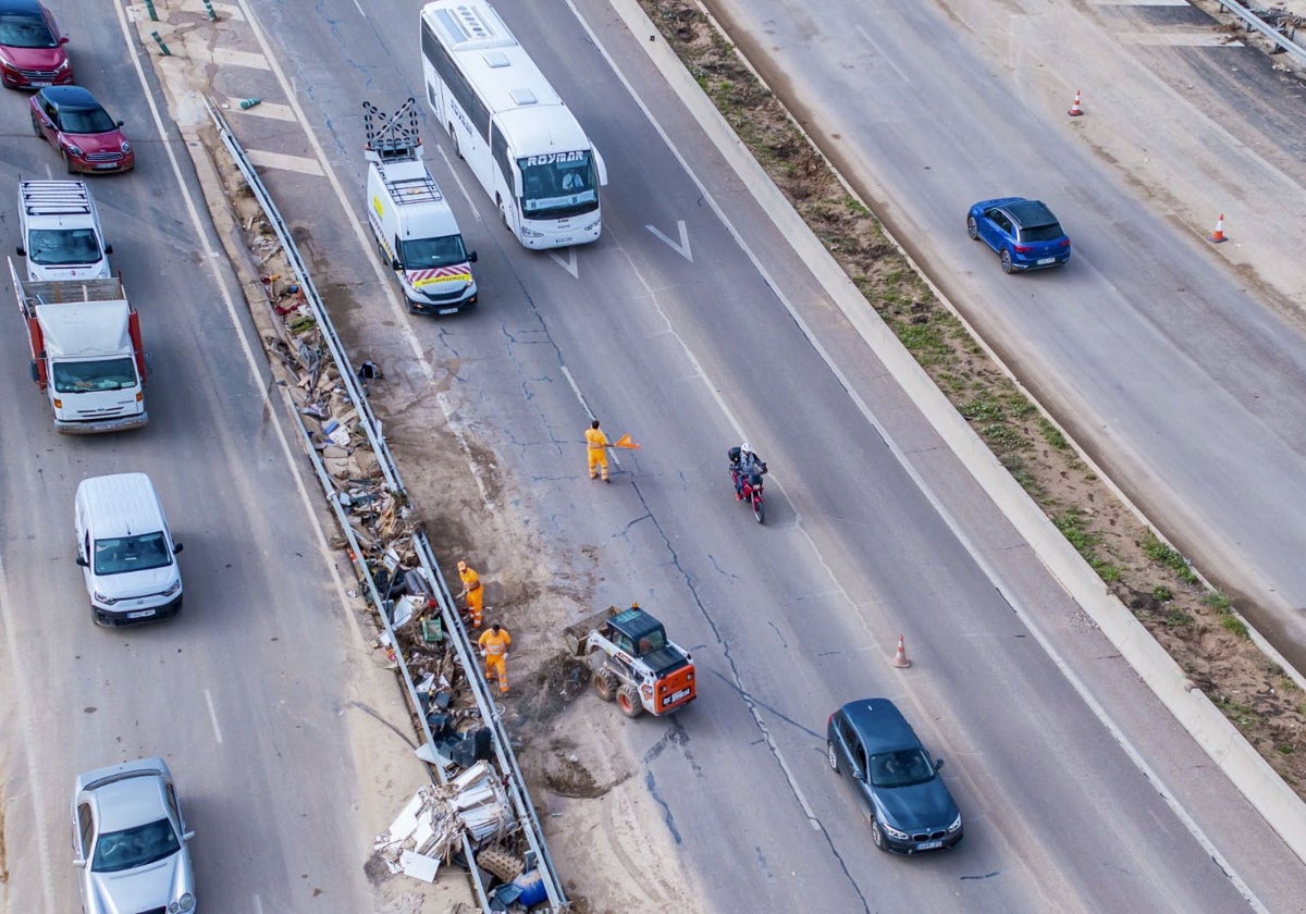 Imagen de los trabajos de retirada de vehículos, este domingo, en la V-31 tras la DANA