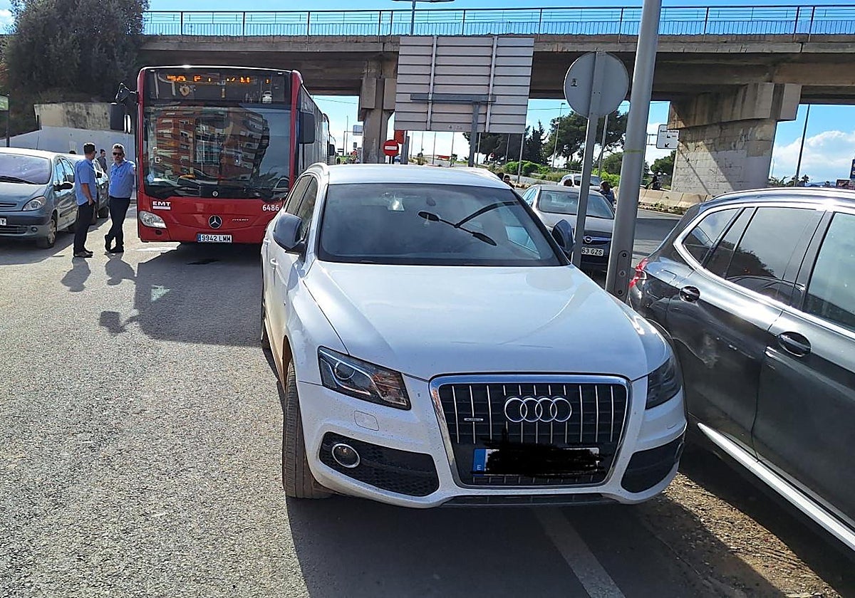 Un coche multado por estar mal aparcado en una vía de tránsito del trasporte público de Valencia y los servicios de emergencias