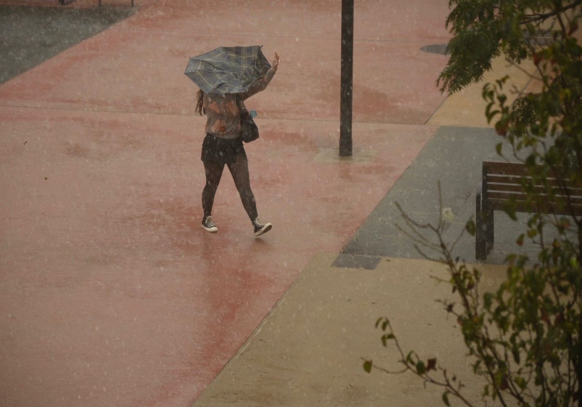 Una mujer, en plena tormenta, con su paraguas, en Barcelona