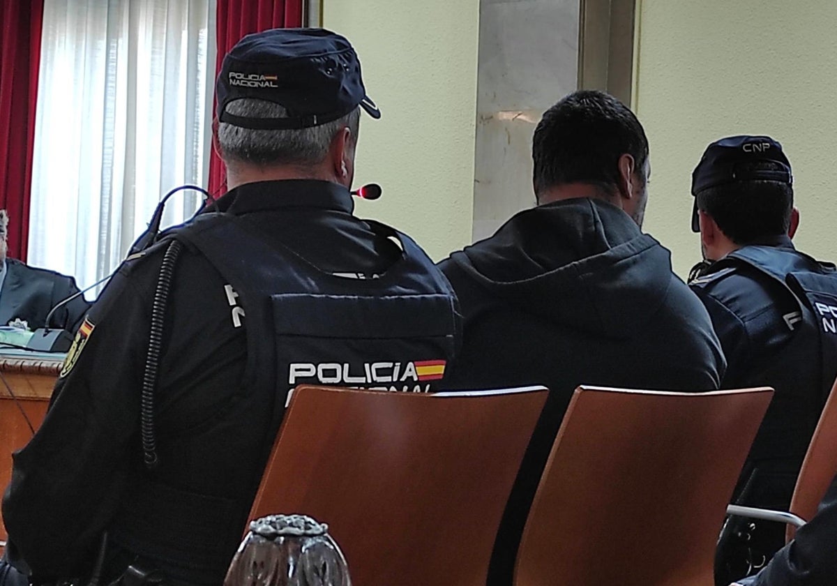 El acusado, entre dos agentes de Policía, durante el juicio