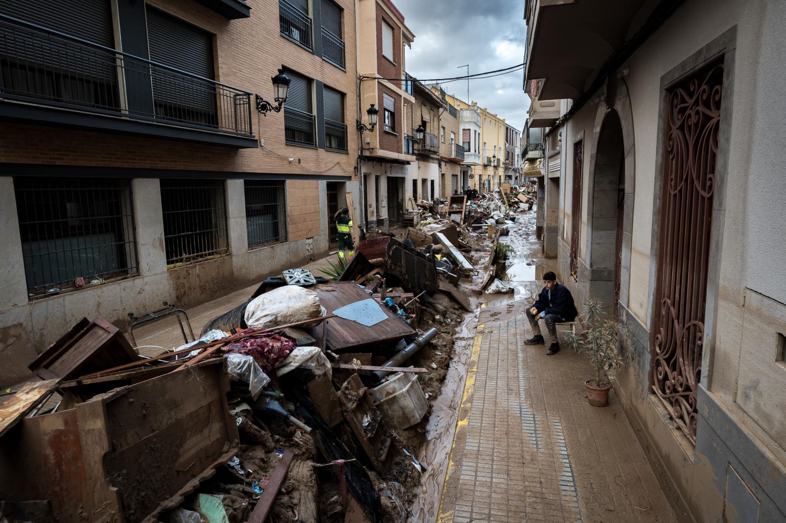 Un joven observa los estragos ocasionados por la DANA en su calle, en Paiporta. Valencia