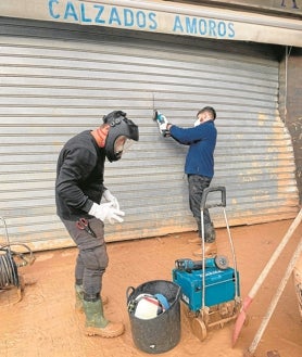 Imagen secundaria 2 - Una de las furgonetas cargadas con material llegadas desde la Moraña, jóvenes de la comarca de Mota del Marqués junto a bomberos y voluntarios y Óscar Tejido con uno de sus amigos durante su labor en Valencia 