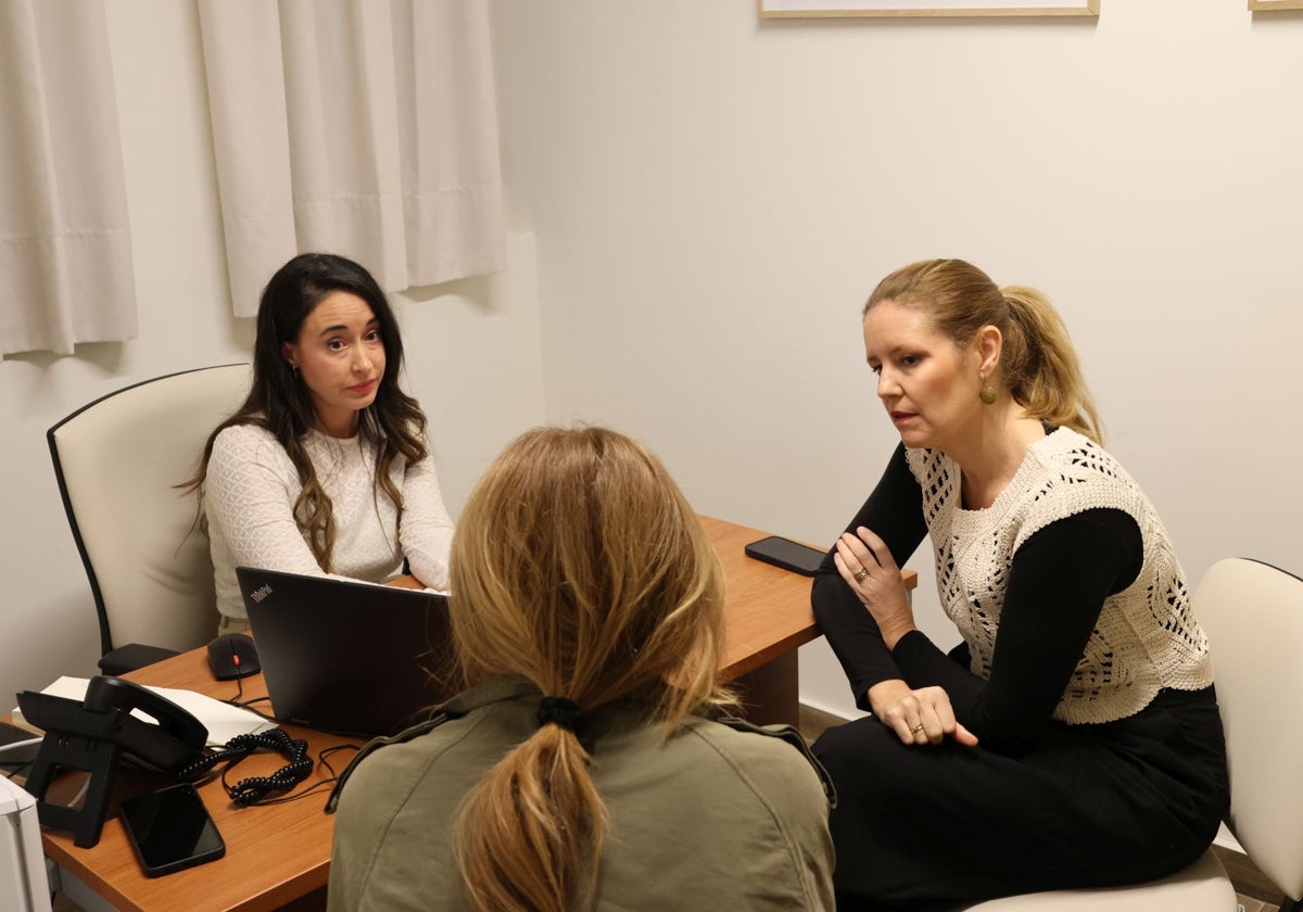 La consejera y la coordinadora del centro hablan con una de las mujeres agredidas (de espaldas)