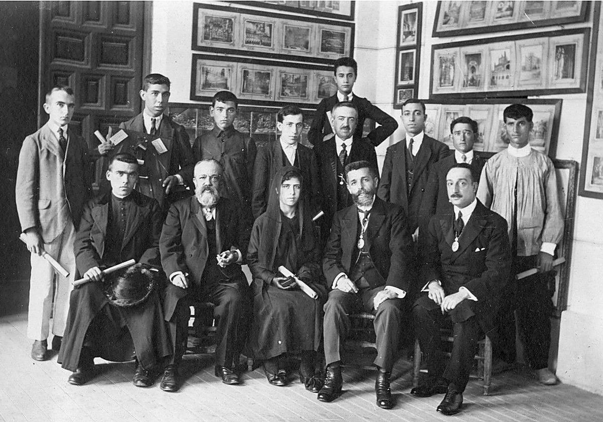 Delante, el primero sentado a la derecha, Álvaro González Saz (1883-1936) el día de su discurso de entrada en la Real Academia de Bellas Artes y Ciencias Históricas de Toledo (30-junio-1918). A su lado, el académico, Adolfo Aragonés de la Encarnación y, el segundo por la izquierda, el director Rafael Ramírez de Arellano. Con un diploma en la mano son los premiados de distintos centros por la institución en la galería del Ayuntamiento. Fotografía de Rodríguez