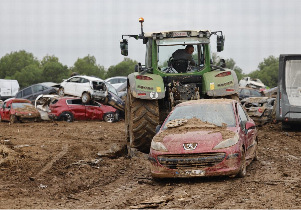 Un agricultor retira vehículos arrastrados por la DANA en Valencia con su tractor