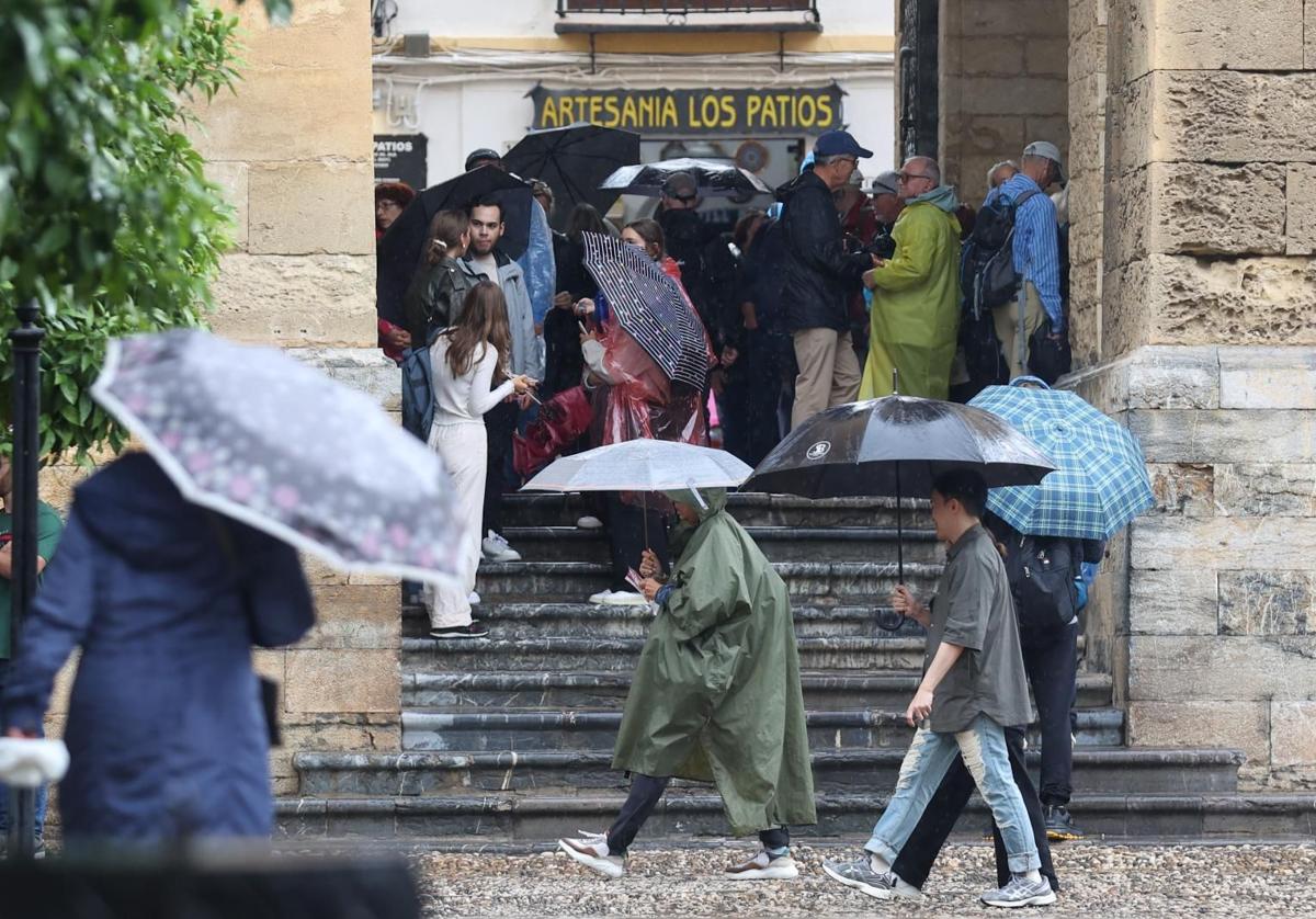 Turistas resguardándose de la lluvia en la Mezquita-Catedral