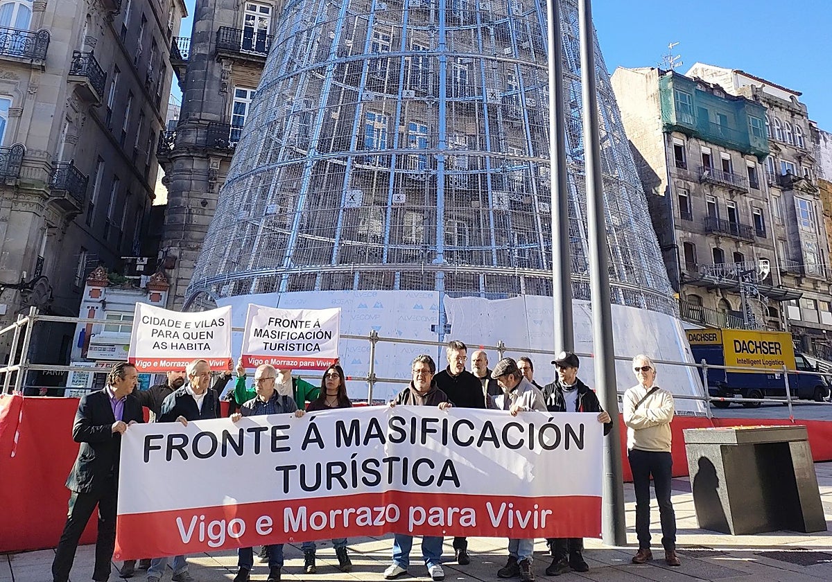 Integrantes de la Plataforma contra la Masificación Turística Vigo-O Morrazo, frente al árbol gigante de Navidad instalado en el centro de la ciudad olívica