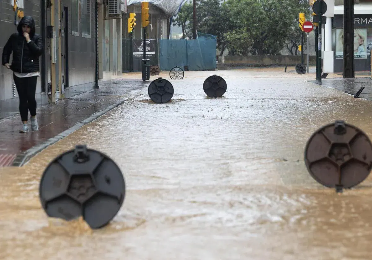 Alcantarillas abiertas en una calle de la barriada de Campanillas por la DANA