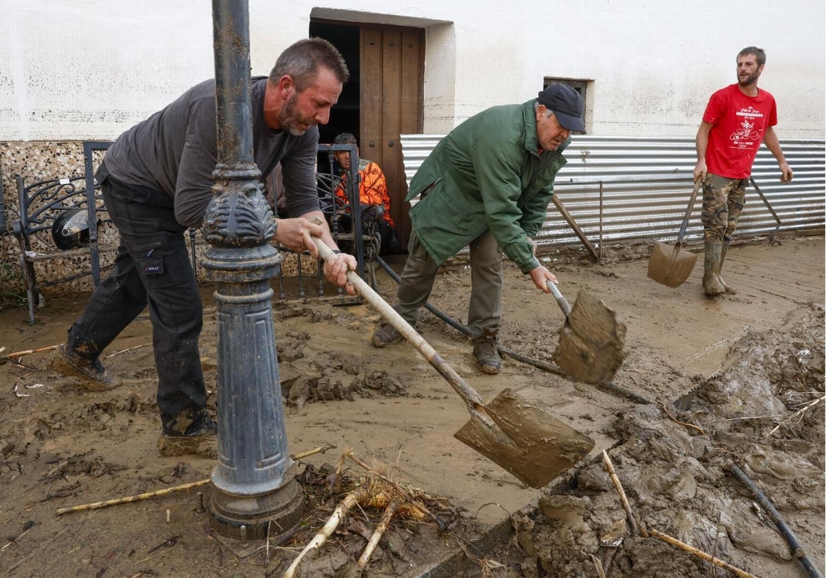 Vecinos en labores de retirada de lodo de las calles de Benamargosa (Málaga)