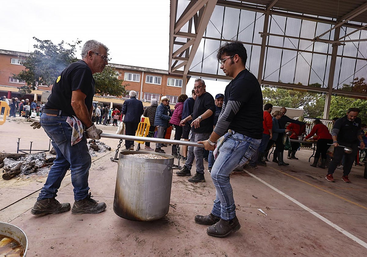 Voluntarios transportan arroz en calderos para las personas que trabajan en la limpieza en Picanya (Valencia), este sábado