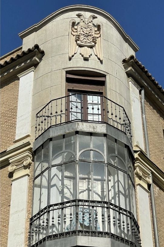 En 1955, el edificio de la familia Navarro Ledesma, pertenecía a la entidad de seguros La Vasco Navarra. Ante el mal estado de la cornisa y el deseo de convertir el ático de una azotea en una planta más para viviendas, encargó a su arquitecto Carlos Sobrini Marín una reforma que incluyó el escudo de la compañía en el chaflán del edificio (Foto RAFAEL DEL CERRO)