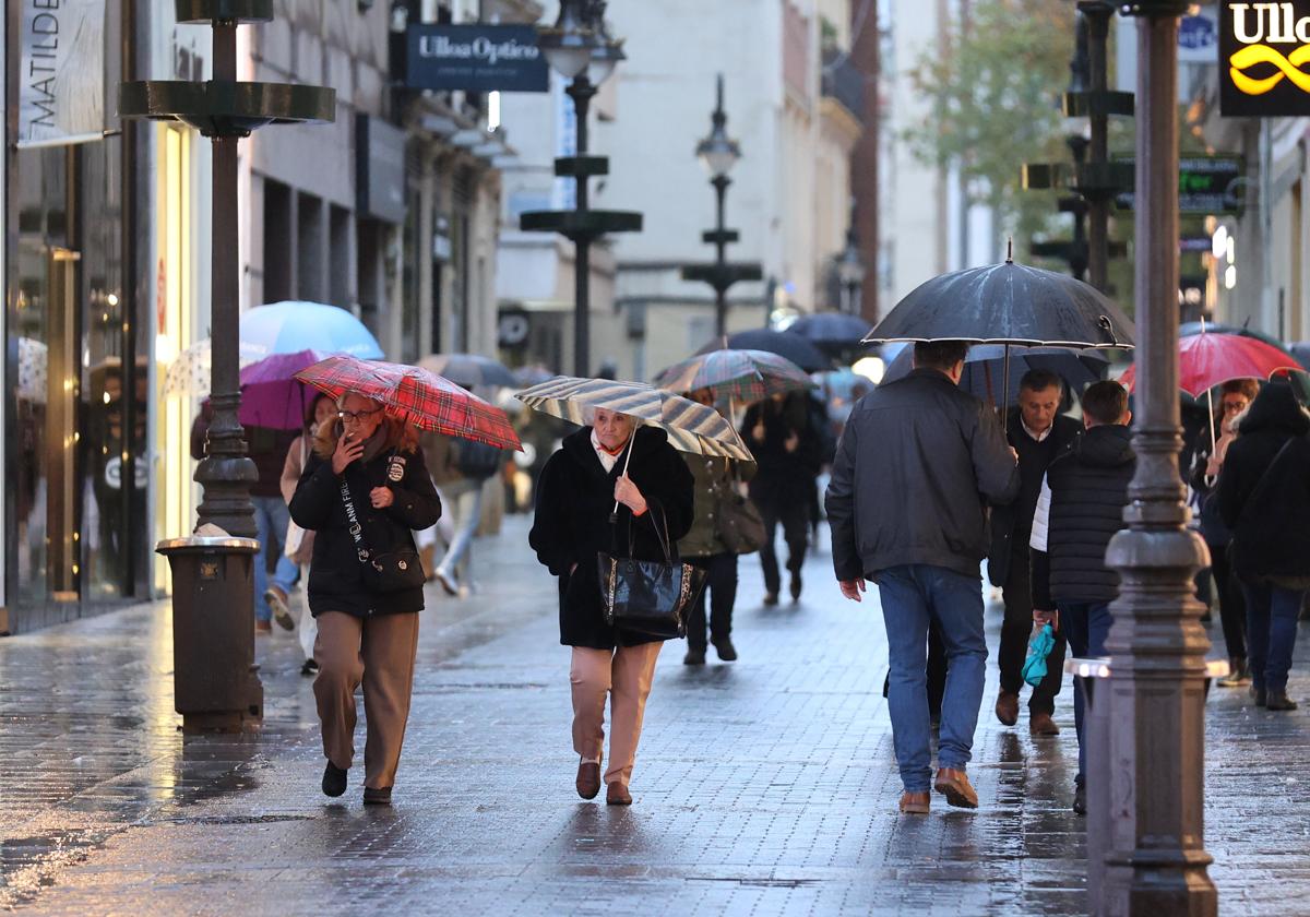 Varias personas se protegen de la lluvia en el Centro