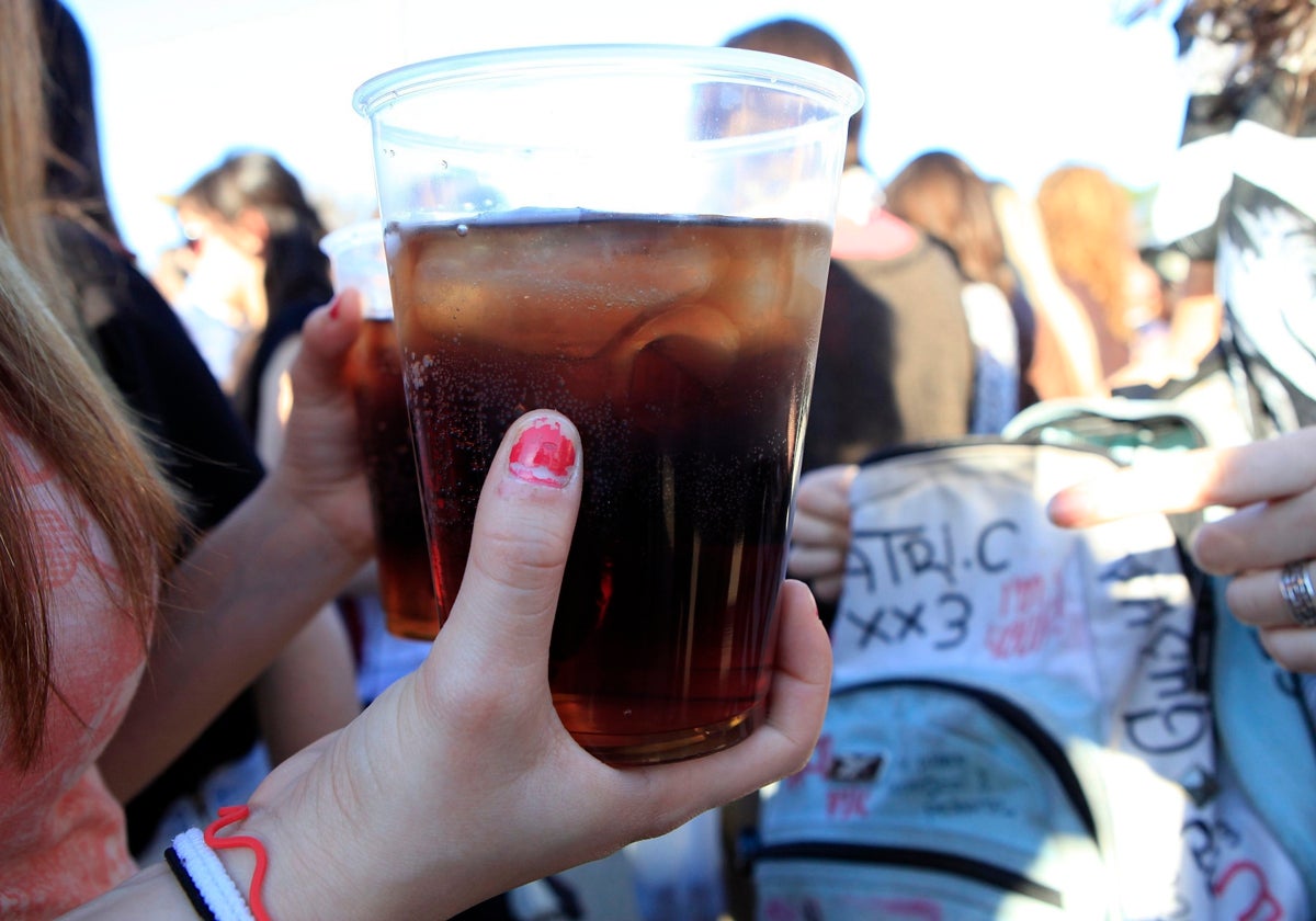 Una chica sostiene dos vasos en un botellón, en una imagen de archivo