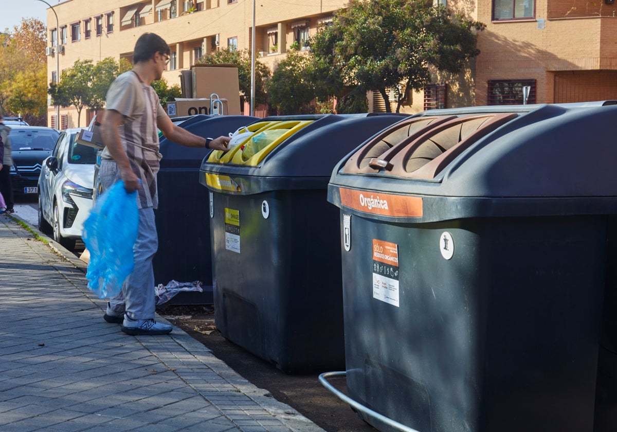 Un madrileño tirando la basura al contenedor