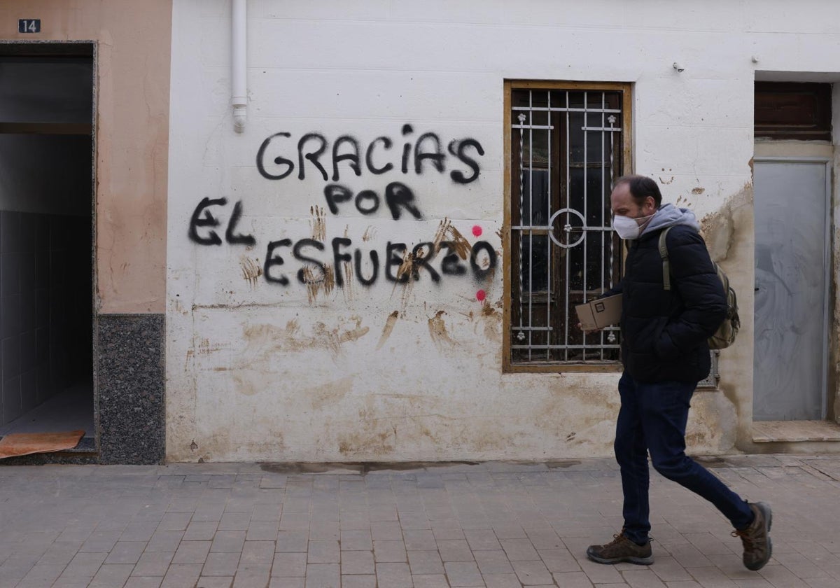 Pintada de reconocimiento de los voluntarios en una fachada en Paiporta