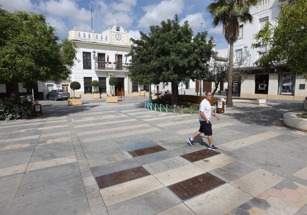 Un vecino paseando por la plaza de un pueblo de Córdoba.