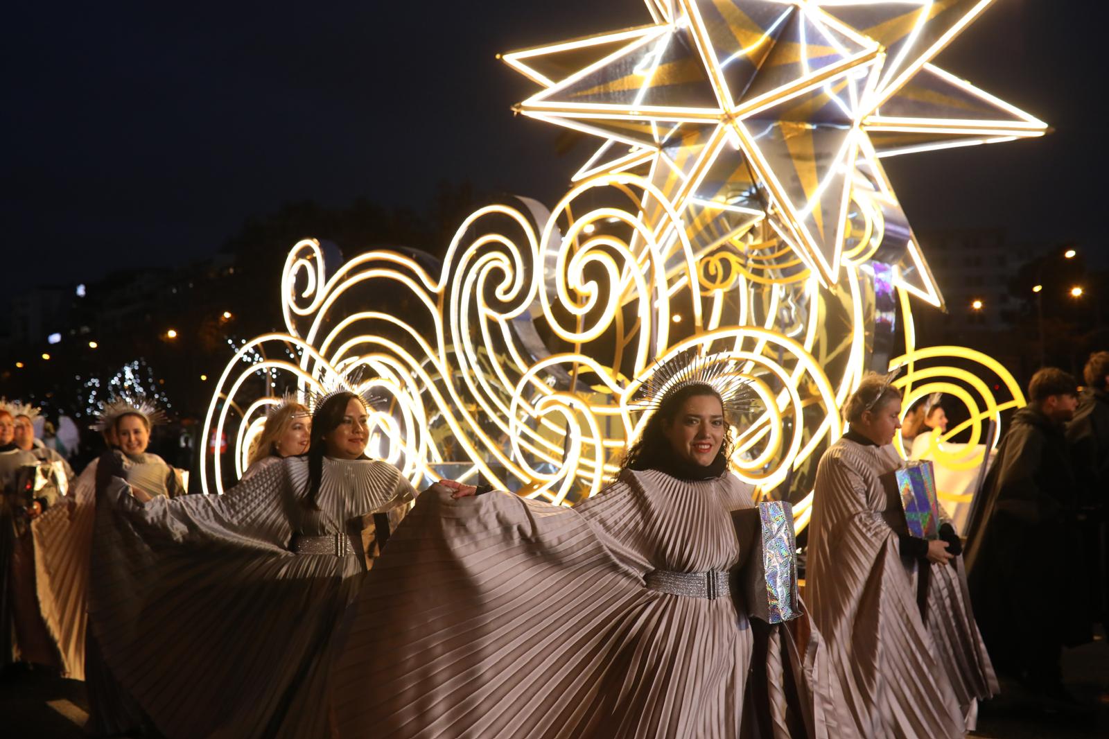 Varias mujeres simbolizan la estrella de la Navidad en el recorrido de la cabalgata de Madrid