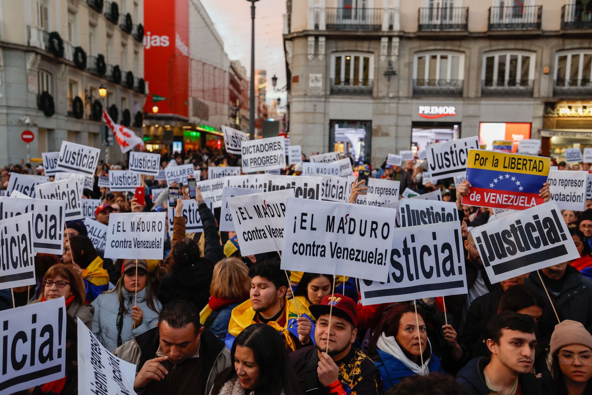 Asistentes a la protesta en Sol sostienen pancartas pidiendo justicia y en contra de Nicolás Maduro.