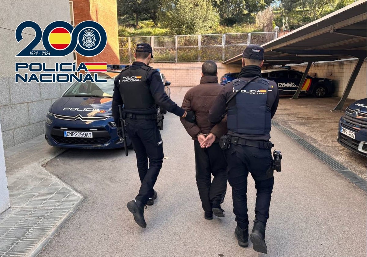 Dos agentes de la Policía Nacional con el fugitivo detenido