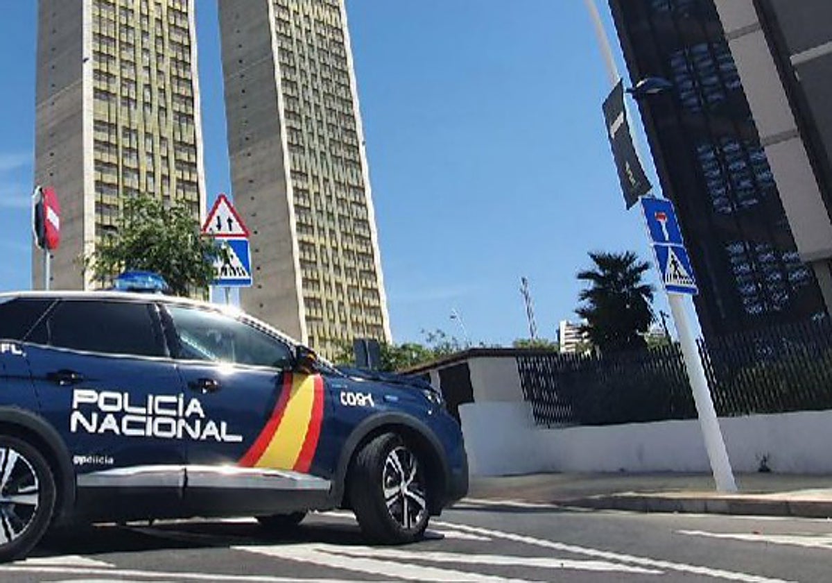 Un coche patrulla de la Policía Nacional junto a varios edificios de gran altura en Benidorm