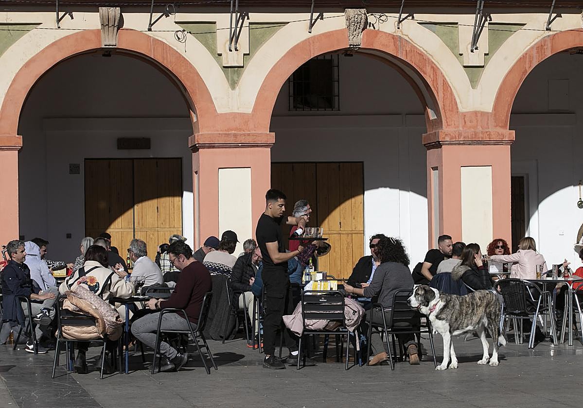 Un camarero atiende una mesa en la plaza de la Corredera