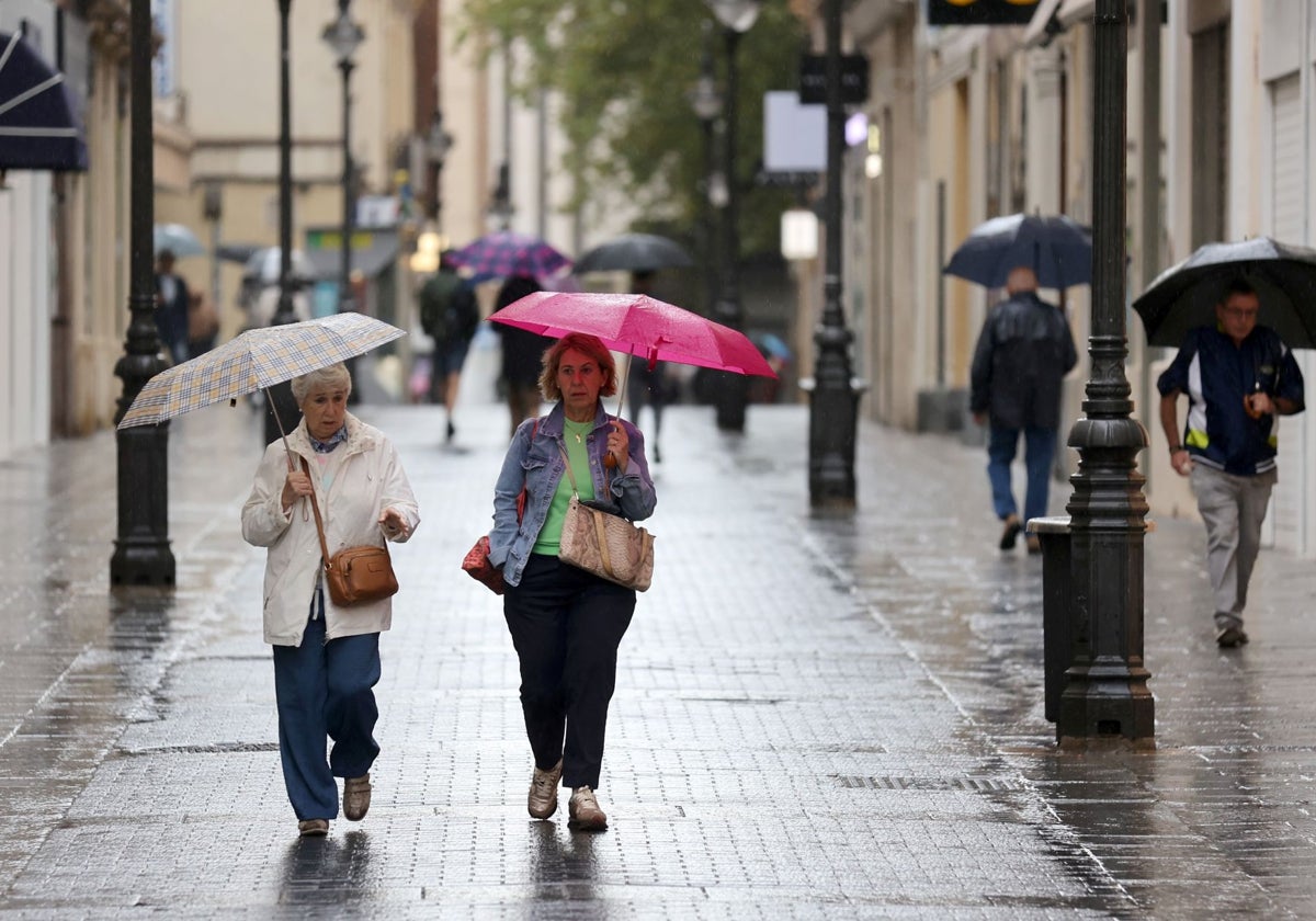 Dos mujeres se protegen de la lluvia en Córdoba