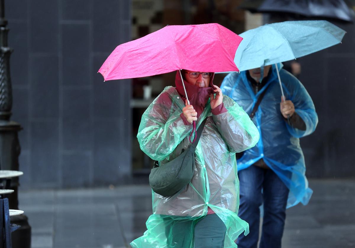 Una mujer se protege de la lluvia en Córdoba