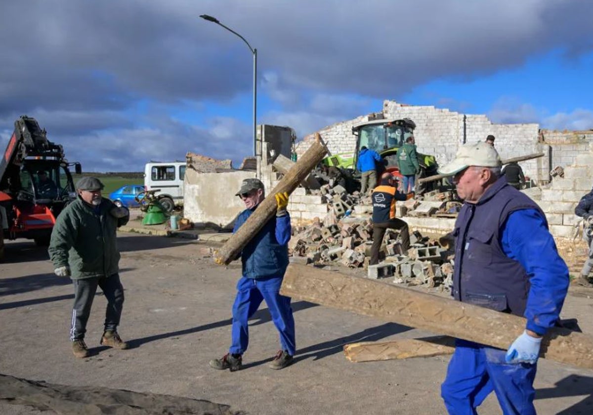 Operarios municipales retiran vigas, ladrillos y otros materiales caídos en la calzada por efecto del fuerte viento