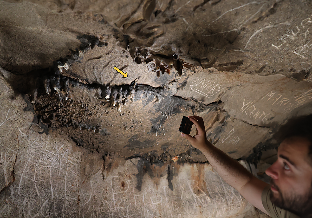El investigador Xabier Garín Artázcoz señala el lugar exacto de la cavidad en el que se halló la moneda