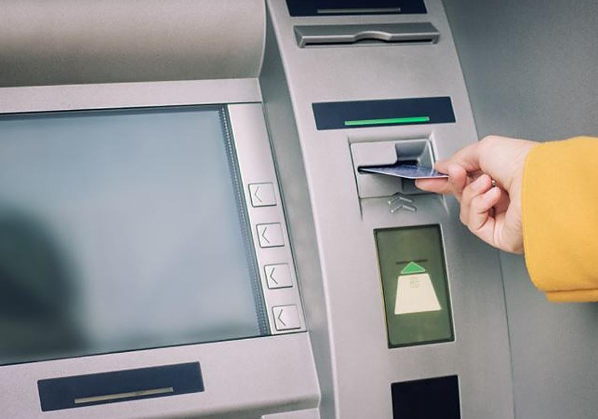 Una mujer saca dinero de un cajero automático