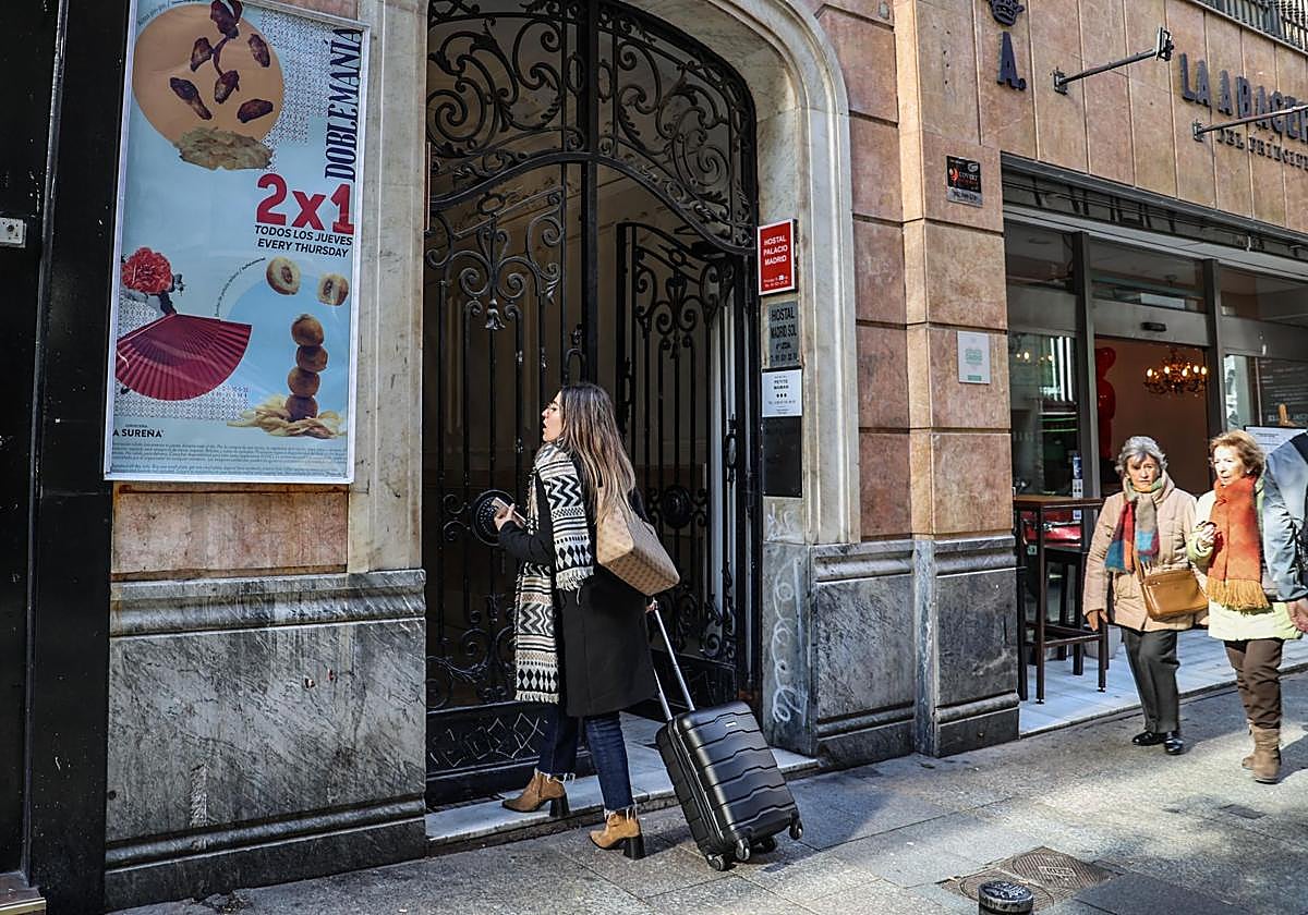 Una joven accede con su maleta a un piso turísticos del centro