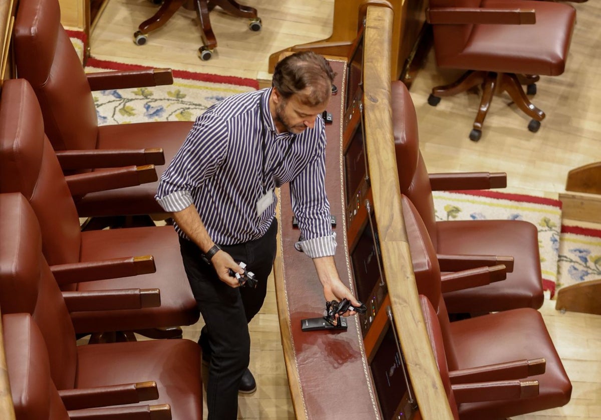 Un técnico coloca auriculares en el hemiciclo del Congreso