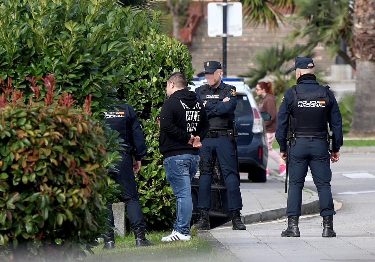 Agentes de la Policía Nacional identifican y cachean a uno de los asistentes a la concentración
