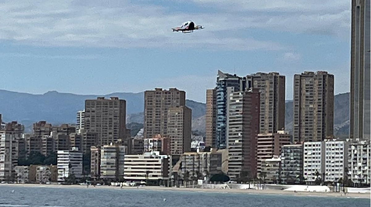El aerotaxi sobrevolando la playa de Levante de Benidorm, junto a los icónicos rascacielos de la ciudad