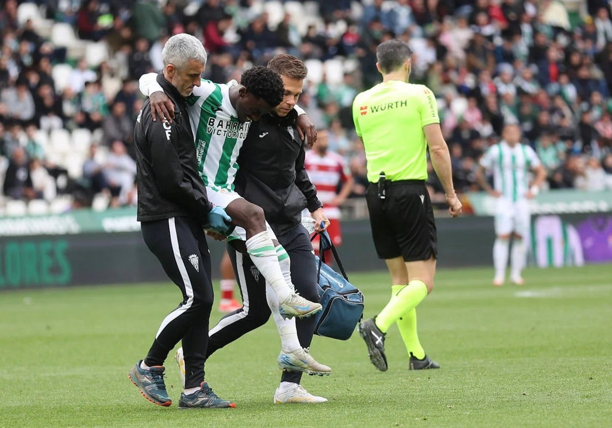Adilson se retira lesionado del terreno de juego con la ayuda del cuerpo técnico
